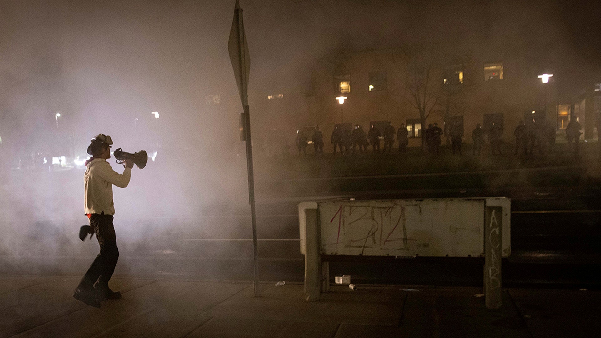A protester confronts police in front of the Brooklyn Center Police station on Sunday, April 11, 2021, in Brooklyn Center, Minnesota. The family of Daunte Wright, 20, told a crowd that he was shot by police Sunday before getting back into his car and driving away, then crashing the vehicle several blocks away. The family said Wright was later pronounced dead.