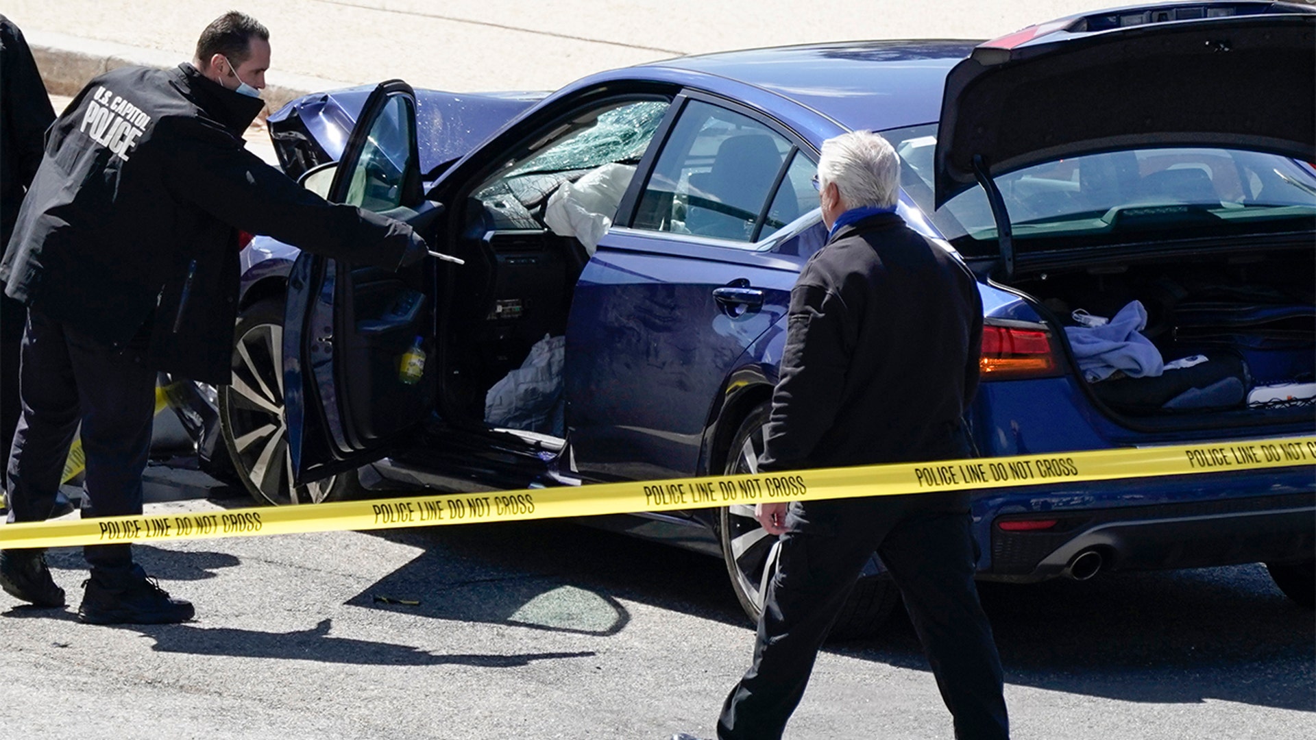 U.S. Capitol Police officers stand near a car that crashed into a barrier on Capitol Hill in Washington, Friday, April 2, 2021. (AP Photo/J. Scott Applewhite)