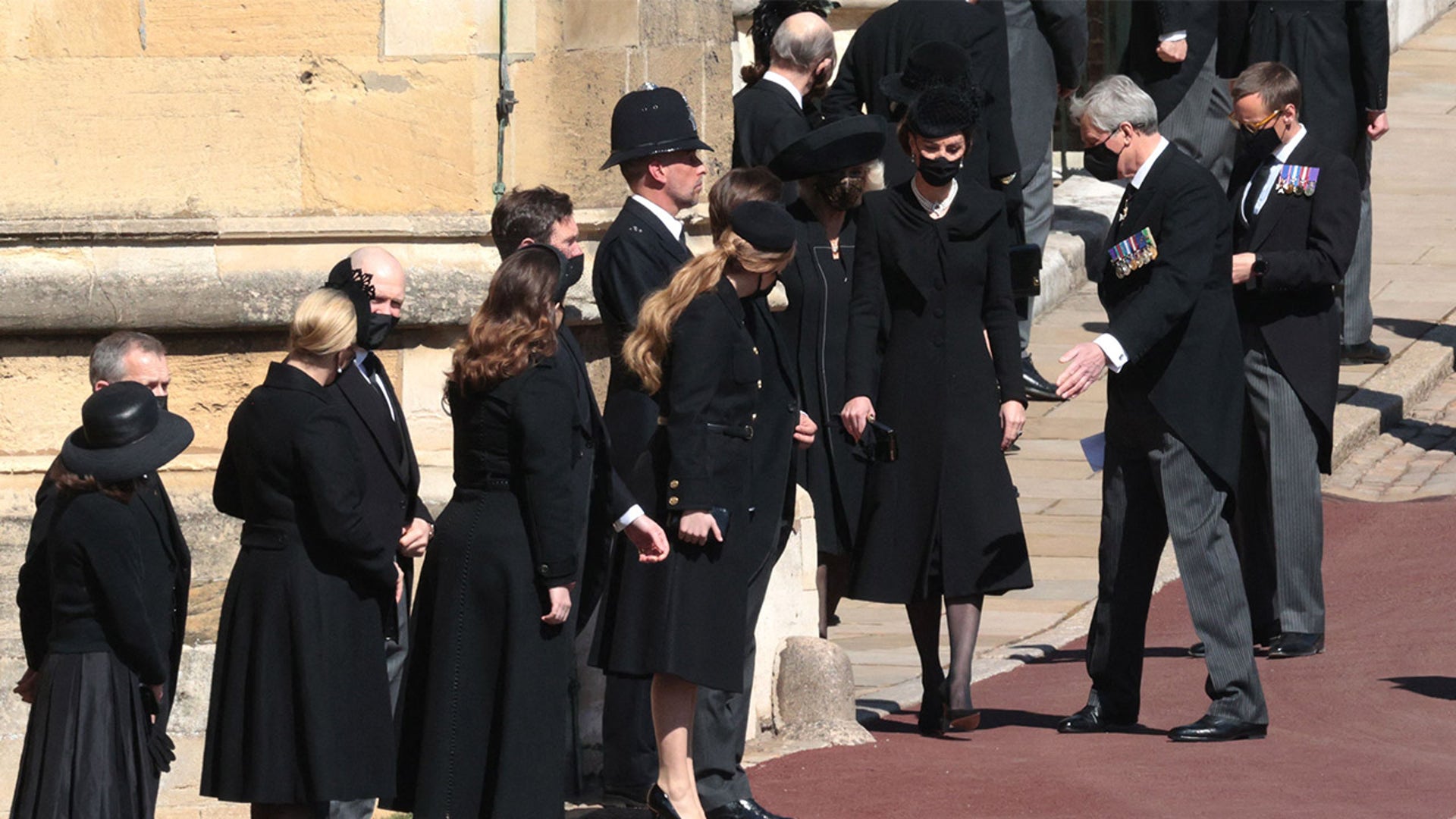 Catherine, Duchess of Cambridge, and members of the royal family stand outside St. George's Chapel on Saturday for the funeral service of Britain's Prince Philip in Windsor Castle. Philip, who was married to Queen Elizabeth II for 73 years, died April 9 at the age of 99, weeks after treatment for a heart condition and infection. (Photo by HANNAH MCKAY / various sources / AFP) (Photo by HANNAH MCKAY/AFP via Getty Images)