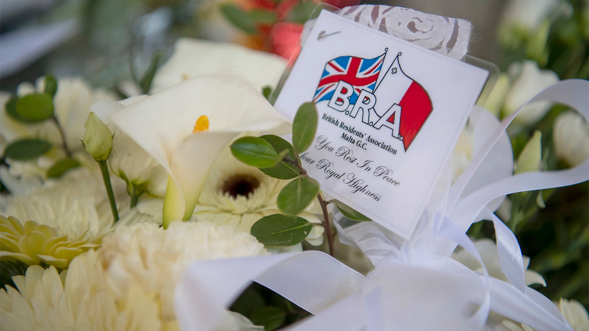 Condolences letters and flowers are laid outside  a former residence of Prince Phillip, Villa Guardamangia in Pieta, in Valletta, Malta, Saturday, April 17, 2021. Prince Philip, husband of Queen Elizabeth II, died earlier this month at the age of 99. His funeral service is taking place Saturday at St. George's Chapel in Windsor Castle. (AP Photo/Rene' Rossignaud)