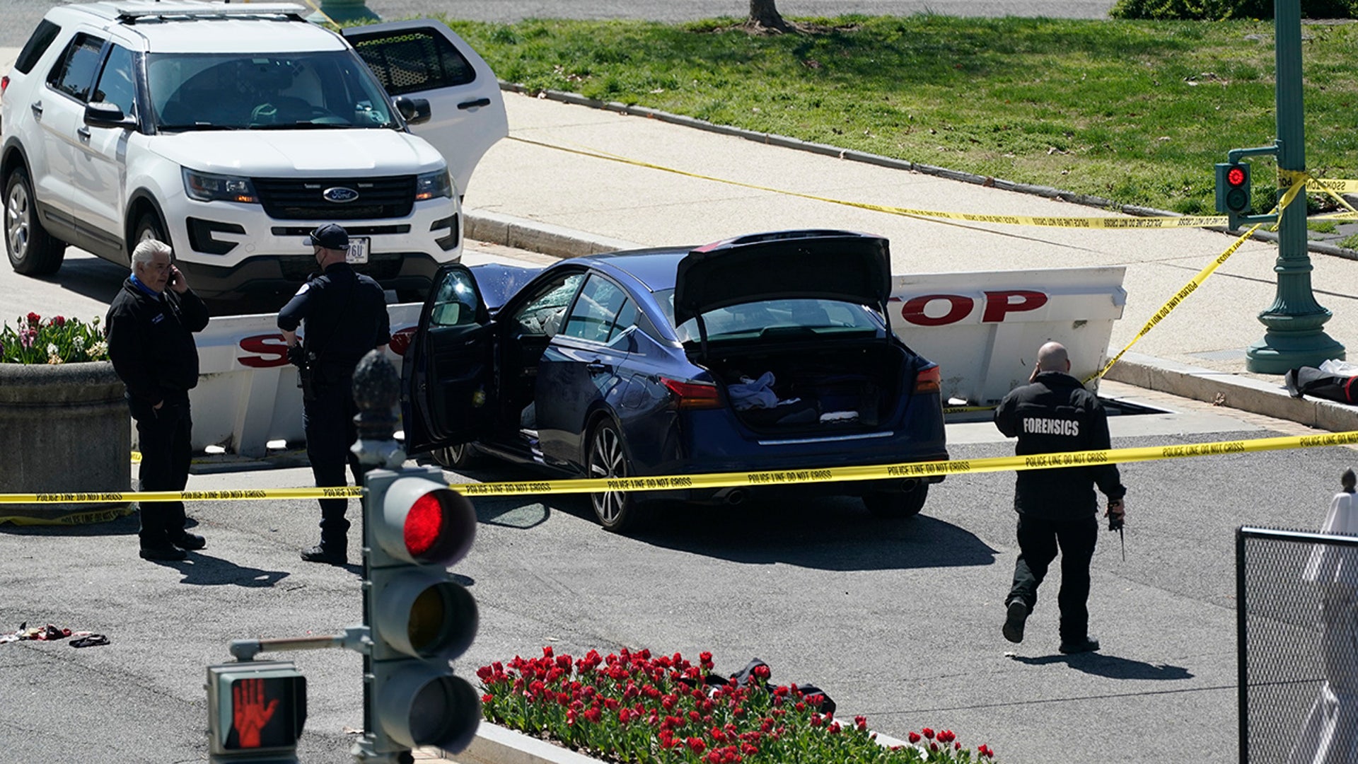 U.S. Capitol Police officers stand near a car that crashed into a barrier on Capitol Hill in Washington, Friday, April 2, 2021. (AP Photo/J. Scott Applewhite)