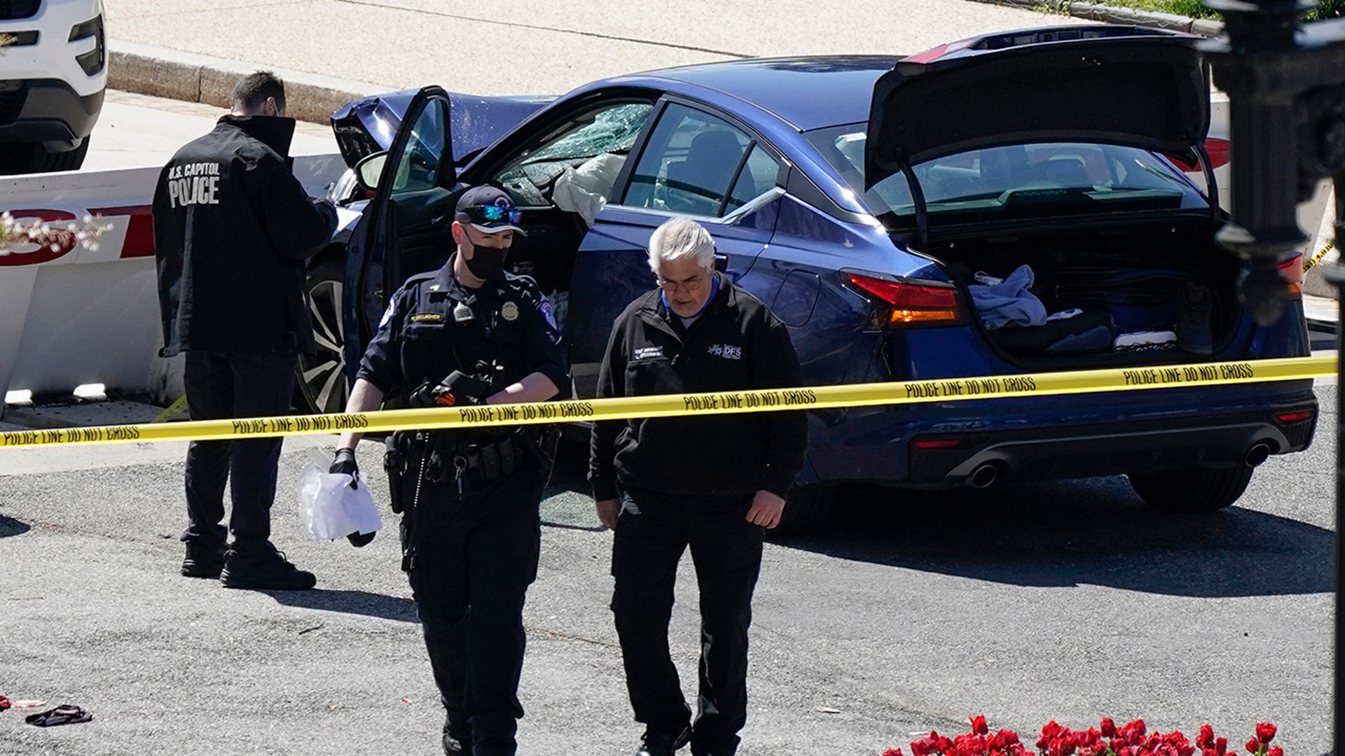 U.S. Capitol Police officers near a car that crashed into a barrier on Capitol Hill in Washington, Friday, April 2, 2021. (AP Photo/J. Scott Applewhite)