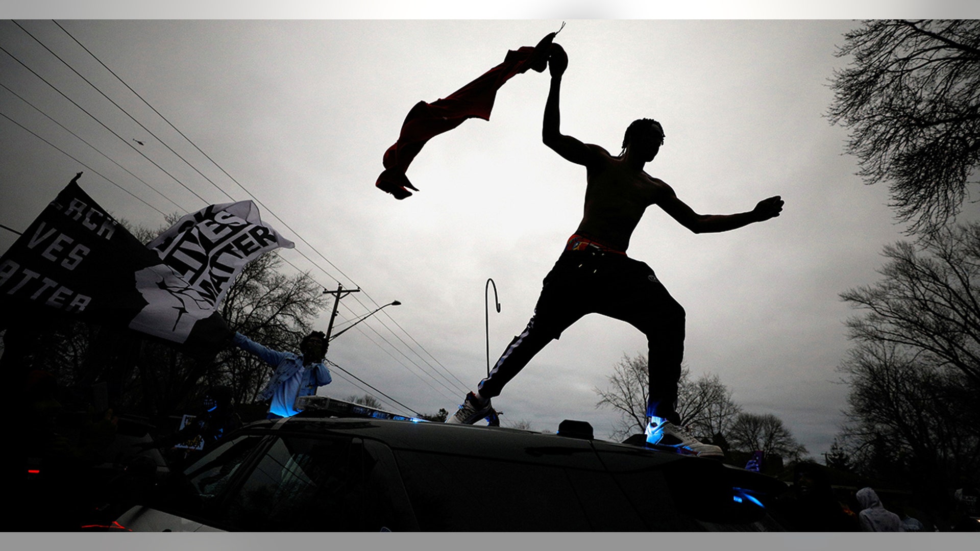 A demonstrator jumps off a police cruiser during a protest after police allegedly shot and killed a man who local media report is identified by the victim's mother as Daunte Wright, in Brooklyn Center, Minnesota, April 11, 2021.