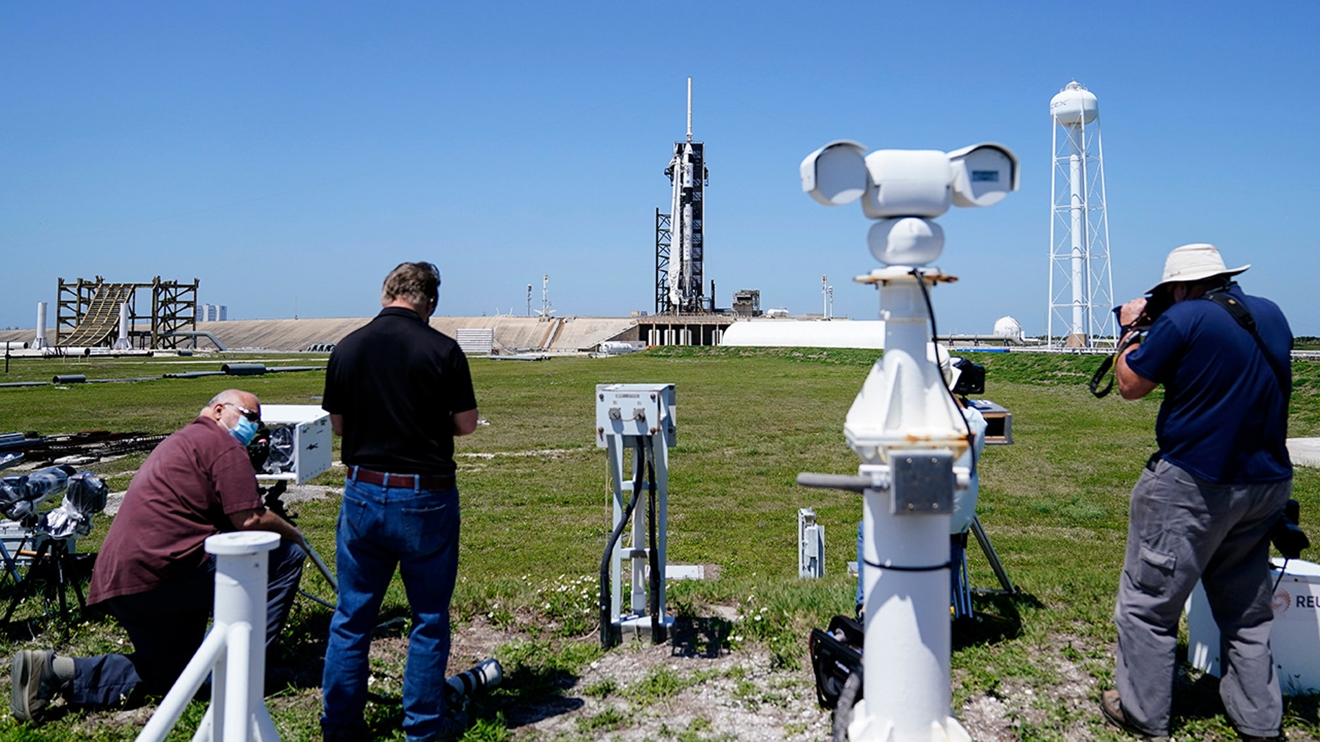 Photographers set up remote cameras before a SpaceX Falcon 9 rocket launch at the Kennedy Space Center on Thursday, April, 22, 2021, in Cape Canaveral, Fla. SpaceX aimed to launch its third crew a little before sunrise Friday, this time using a recycled capsule and rocket. (AP Photo/Brynn Anderson)
