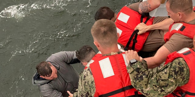 Crew members of the Coast Guard Cutter Glenn Harris pull a person from the water on Tuesday, April 13, 2021 after a commercial lift boat capsized 8 miles south of Grand Isle, La. (AP/U.S. Coast Guard)