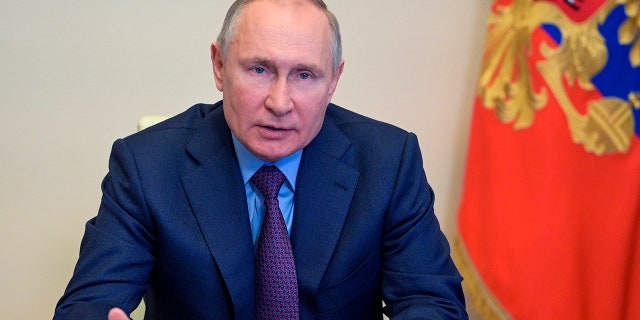 Russian President Vladimir Putin gestures during a meeting via video conference at the Novo-Ogaryovo residence outside Moscow, Russia, Thursday, April 15, 2021. (Alexei Druzhinin, Sputnik, Kremlin Pool Photo via AP)