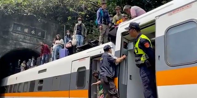 In this image made from a video released by hsnews.com.tw, passengers are helped to climb out of a derailed train in Hualien County in eastern Taiwan Friday, April 2, 2021. (hsnews.com.tw via AP)