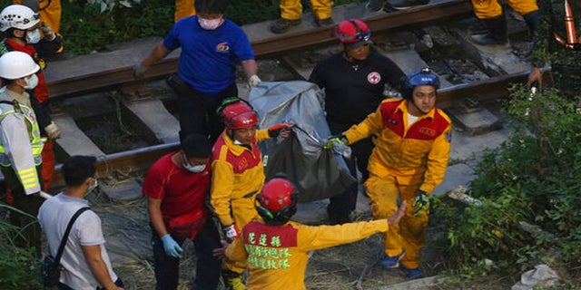 Rescue workers recover a body from a derailed train near the Taroko Gorge area in Hualien, Taiwan, on Friday. (AP)