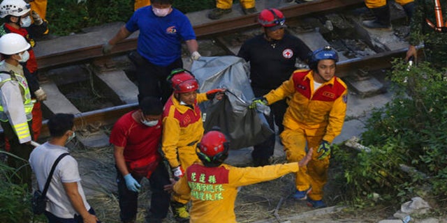 Rescue workers recover a body from a derailed train near the Taroko Gorge area in Hualien, Taiwan, on Friday. (AP)