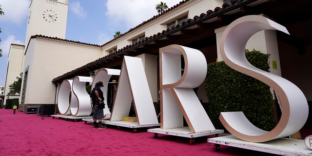 An Academy Awards crew member looks over a background element for the red carpet at Union Station.