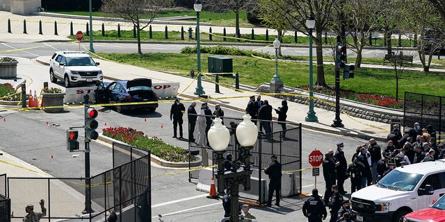 U.S. Capitol Police officers investigate near a car that crashed into a barrier on Capitol Hill near the Senate side of the U.S. Capitol in Washington, Friday, April 2, 2021. (AP Photo/J. Scott Applewhite)