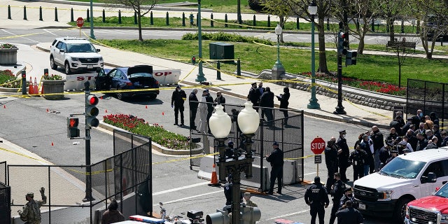 U.S. Capitol Police officers investigate near a car that crashed into a barrier on Capitol Hill near the Senate side of the U.S. Capitol in Washington, Friday, April 2, 2021. (AP Photo/J. Scott Applewhite)