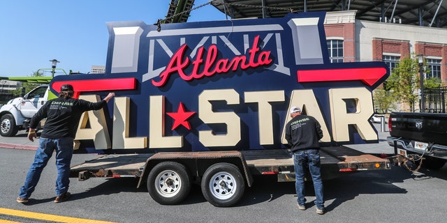 Workers load an All-Star sign onto a trailer after it was removed from Truist Park in Atlanta, Tuesday, April 6, 2021. (John Spink/Atlanta Journal-Constitution via AP)