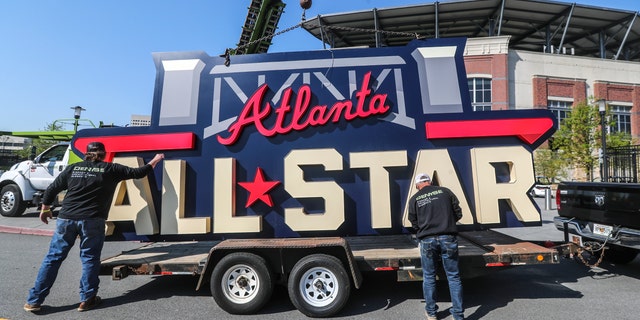 Workers load an All-Star sign onto a trailer after it was removed from Truist Park in Atlanta, Tuesday, April 6, 2021. (John Spink/Atlanta Journal-Constitution via AP)