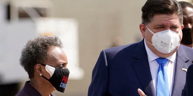 Chicago Mayor Lori Lightfoot and Illinois Gov. J.B. Pritzker greet Vice President Kamala Harris as she arrives in Chicago on April 6, 2021.