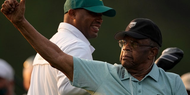 Lee Elder gestures as he arrives for the ceremonial tee shots before the first round of the Masters golf tournament on Thursday, April 8, 2021, in Augusta, Ga.