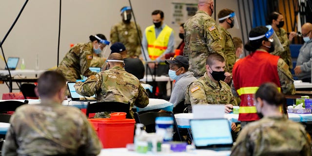 Members of the military inoculate people with the COVID-19 vaccine at the Esperanza Community Vaccination Center in Philadelphia.