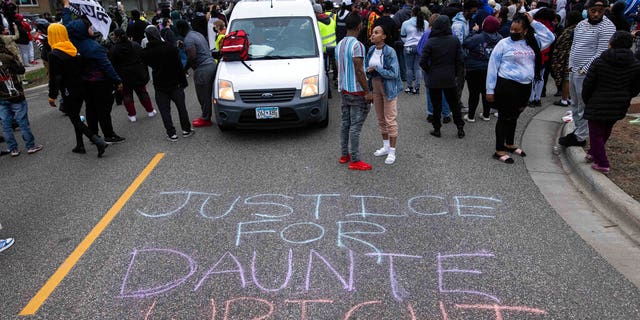 People gather in protest, Sunday, April 11, 2021, in Brooklyn Center, Minn.