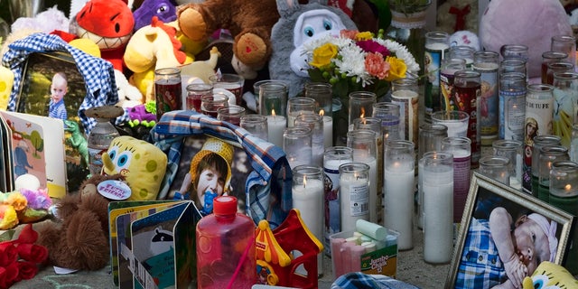 Photos, candles, flowers and balloons are placed as a memorial for three children who were killed at the Royal Villa apartments complex in the Reseda section of Los Angeles. Authorities have identified 3-year-old Joanna Denton Carrillo, her 2-year-old brother, Terry, and 6-month-old sister, Sierra. (AP Photo/Richard Vogel)
