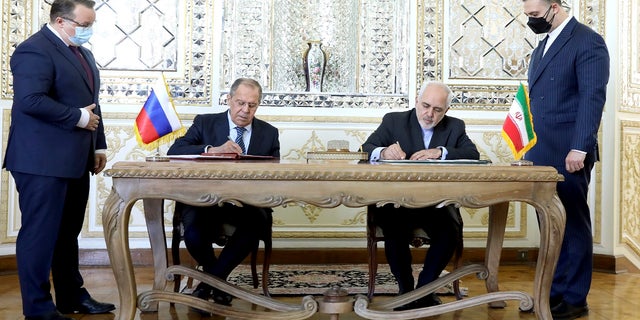 Former Iranian Foreign Minister Mohammad Javad Zarif, center right, and his Russian counterpart Sergey Lavrov, center left, sign agreements after their talks in Tehran, Iran, in April 2021. 