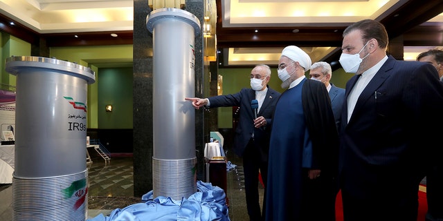 Mantan Presiden Hassan Rouhani, kedua kanan, mendengarkan kepala Organisasi Energi Atom Iran, Ali Akbar Salehi, saat mengunjungi pameran pencapaian nuklir baru Iran di Teheran, Iran, pada April 2021.