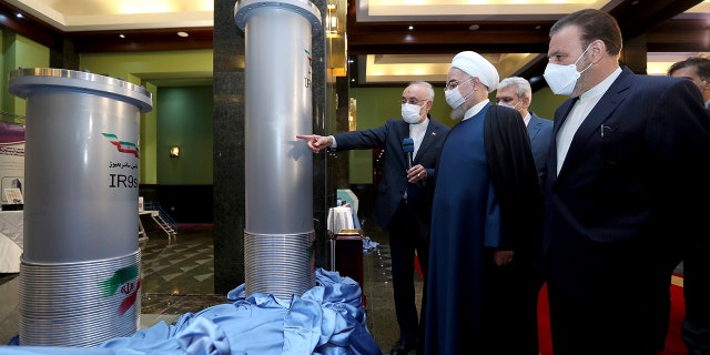 Former President Hassan Rouhani, second right, listens to head of the Atomic Energy Organization of Iran Ali Akbar Salehi while visiting an exhibition of Iran's new nuclear achievements in Tehran, Iran, in April 2021 