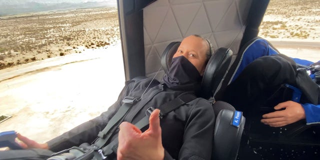 In this photo made available by Blue Origin, Audrey Powers gives a thumbs up inside the New Shepard rocket capsule during a crew rehearsal in West Texas on Wednesday, April 14, 2021. Two employees were strapped into the fueled rocketship for practice, but they disembarked shortly before the capsule launched to the edge of space with only a test dummy. (Blue Origin via AP)