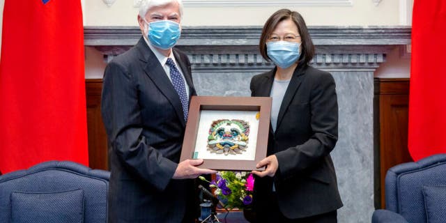 In this photo released by the Taiwan Presidential Office, Taiwan President Tsai Ing-wen, right, poses for photos with former U.S. senator Chris Dodd during a meeting in Taipei, Taiwan on Thursday, April 15, 2021. (Taiwan Presidential Office via AP)