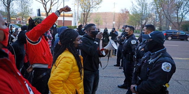 Activist Ja'Mal Green, center, along with other protestors react towards a line of Chicago police officers during a rally outside of Chicago police headquarters after the body camera video release of fatal police shooting of 13-year-old Adam Toledo on Thursday, April 15, 2021. (AP Photo/Shafkat Anowar)