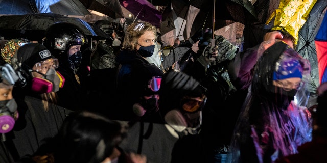 Demonstrators using umbrellas as shields against potential crowd control weapons take part in a protest in response to the fatal shooting of Daunte Wright during a traffic stop, outside the Brooklyn Center (Minn.) Police Department on Thursday, April 15, 2021. (Associated Press)