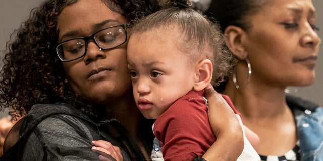 Daunte Wright Jr, center, son of the deceased Daunte Wright, cries in the eyes of his mother Chyna Whitaker, left, alongside his grandmother Erica Whitaker during a Friday news conference in Minneapolis. (AP Photo/John Minchillo)