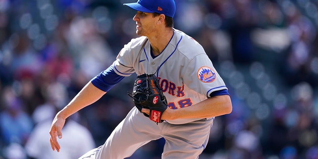 New York Mets starting pitcher Jacob deGrom watches a throw to Colorado Rockies' C.J. Cron during the fourth inning of a doubleheader, April 17, 2021, in Denver.