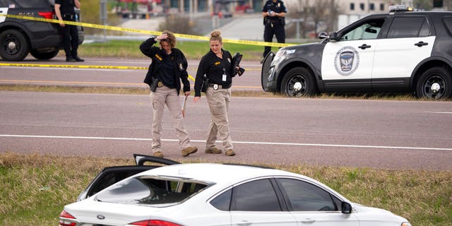 Two Bureau of Criminal Apprehension agents begin investigating the scene of an officer-involved shooting, Sunday, April 18, 2021, in Burnsville, Minn.