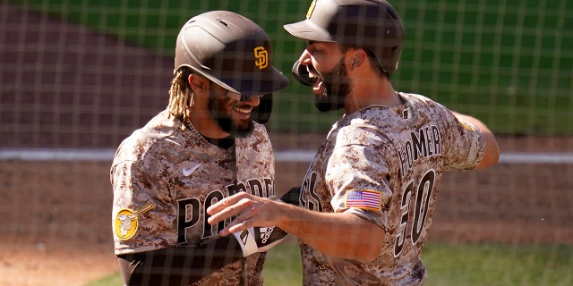 San Diego Padres' Eric Hosmer, right, celebrates with teammate Fernando Tatis Jr. after they both scored during the eighth inning against the Los Angeles Dodgers, April 18, 2021, in San Diego, California.