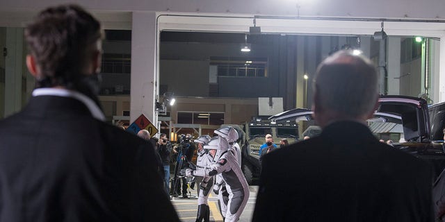 SpaceX Chief Engineer Elon Musk, left, and acting NASA Administrator Steve Jurczyk, right, watch as ESA (European Space Agency) astronaut Thomas Pesquet, Japan Aerospace Exploration Agency (JAXA) astronaut Akihiko Hoshide, and NASA astronauts Shane Kimbrough and Megan McArthur, prepare to depart the Neil A. Armstrong Operations and Checkout Building for Launch Complex 39A to board the SpaceX Crew Dragon spacecraft for the Crew-2 mission launch, Friday, April 23, 2021, at NASA's Kennedy Space Center in Florida. (Aubrey Gemignani/NASA via AP)