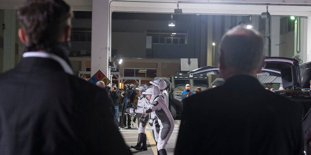 SpaceX Chief Engineer Elon Musk, left, and acting NASA Administrator Steve Jurczyk, right, watch as ESA (European Space Agency) astronaut Thomas Pesquet, Japan Aerospace Exploration Agency (JAXA) astronaut Akihiko Hoshide, and NASA astronauts Shane Kimbrough and Megan McArthur, prepare to depart the Neil A. Armstrong Operations and Checkout Building for Launch Complex 39A to board the SpaceX Crew Dragon spacecraft for the Crew-2 mission launch, Friday, April 23, 2021, at NASA's Kennedy Space Center in Florida. (Aubrey Gemignani/NASA via AP)