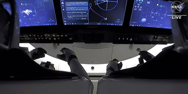 In diesem Bild aus dem NASA-Fernsehen sind die Astronauten im Cockpit des Raumfahrzeugs SpaceX Crew Dragon zu sehen, während sich das Raumschiff auf das Andocken an die internationale Raumstation am Samstag, den 24. April 2021 vorbereitet. Die recycelte SpaceX-Kapsel mit vier Astronauten ist angekommen die Internationale Raumstation, einen Tag nach dem Start von Florida (NASA via AP)
