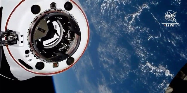 This image from NASA TV shows the SpaceX Crew Dragon spacecraft, with Earth behind, approaching the International Space Station, on Saturday 24 April 2021. The recycled SpaceX capsule with four astronauts arrived at the International Space Station a day after its launch .  of Florida.  (NASA via AP)