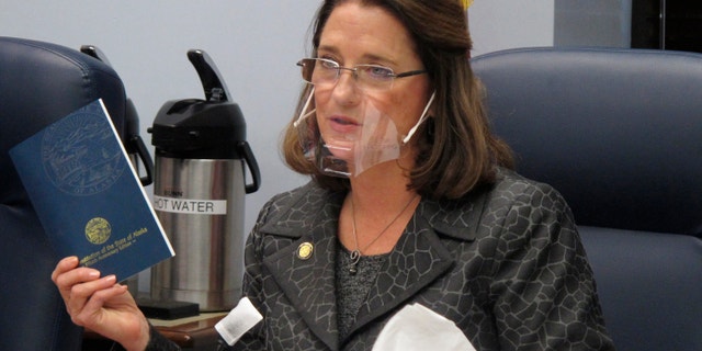 Alaska state Sen. Lora Reinbold, an Eagle River Republican, holds a copy of the Alaska Constitution during a committee hearing in Juneau in this January 2021 photo.