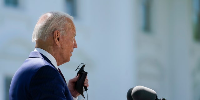 President Biden removes his face mask to speak about COVID-19, on the North Lawn of the White House, Tuesday, April 27, 2021, in Washington. (AP Photo/Evan Vucci)