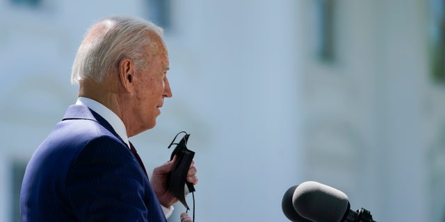 President Biden removes his face mask to speak about COVID-19, on the North Lawn of the White House, Tuesday, April 27, 2021, in Washington. (AP Photo/Evan Vucci)