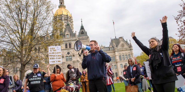 Joining thousands gathered outside the State Capitol, opponents of a bill to repeal Connecticut's religious exemption for school vaccinations pray outside the Capitol before the State Senate voted on the legislation, Tuesday, April 27, 2021, in Hartford, Conn. (Mark Mirko/Hartford Courant via AP)