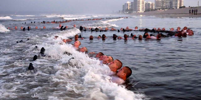 U.S. Navy SEAL candidates participating in "surf immersion" during Basic Underwater Demolition/SEAL training at the Naval Special Warfare Center in Coronado, California, May 4, 2020. U.S. Navy SEALs are undergoing a major transition to improve leadership and expand their commando capabilities. (MC1 Anthony Walker/U.S. Navy via AP)