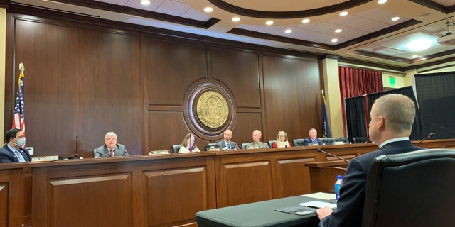 Idaho state Rep. Aaron von Ehlinger, right, a Republican from Lewiston, watches as members of the House ethics committee discuss whether he acted in a way that was "unbecoming" to his position in connection with rape allegations brought against him by a 19-year-old intern, during a hearing in Boise, Idaho, on Thursday, April 29, 2021. The committee unanimously agreed on Thursday that von Ehlinger should be formally censured and suspended from his office, and that a new lawmaker should be appointed to serve in his place. The full House could vote on the matter as soon as Friday. (AP Photo/Rebecca Boone)