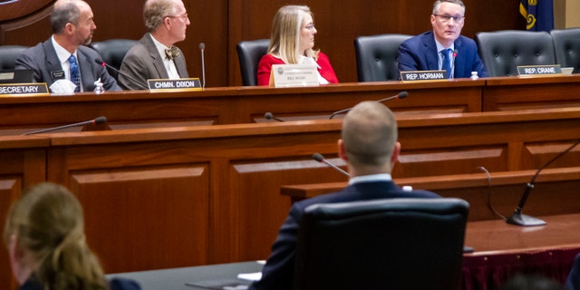 The Idaho Ethics and House Policy Committee votes during a hearing regarding state Rep. Aaron von Ehlinger, center back to camera, Thursday, April 29, 2021, in Boise, Idaho. The committee agreed that von Ehlinger, accused of rape by a 19-year-old intern, should be formally censured and suspended from office. The full House could vote on the matter as soon as Friday. (Darin Oswald/Idaho Statesman via AP)