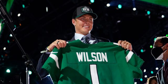 BYU quarterback Zach Wilson holds a New York Jets jersey after being selected second overall in the first round of the NFL football draft Thursday, April 29, 2021, in Cleveland. (AP Photo/Tony Dejak)