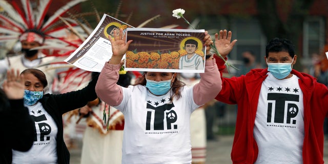 Demonstrators raise their hand as they attend a peace walk honoring the life of Adam Toledo on Sunday in Chicago's Little Village neighborhood. (AP)