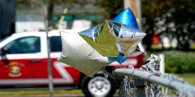 Balloons are seen tied to a fence in Elizabeth City, N.C., at the scene where Brown was shot. (AP)