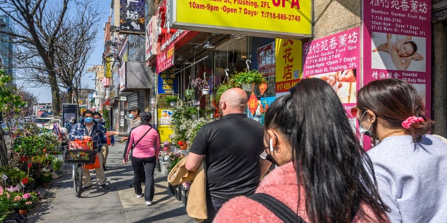 Volunteers of Main Street Patrol keep a watchful eye as they walk up and down the streets of Flushing on Sunday, April 4, 2021, in New York. From coast-to-coast, Asian American groups were already doing more than digital activism, including patrolling, escorting, and chaperoning in Asian communities. Now, those activities are only increasing. (AP Photo/Brittainy Newman)