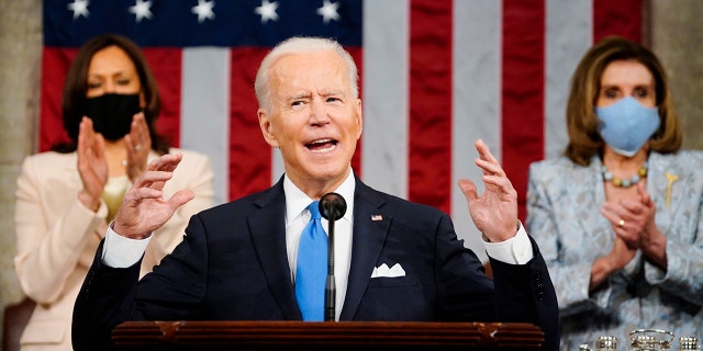 Vice President Kamala Harris and House Speaker Nancy Pelosi of California stand and applaud as President Biden addresses a joint session of Congress April 28, 2021, in the House Chamber at the U.S. Capitol in Washington. 